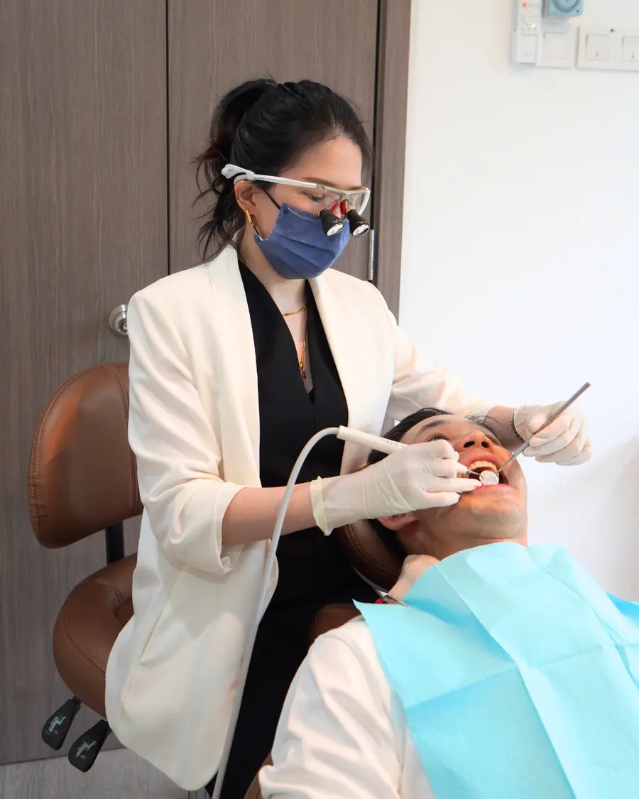 Dentist wearing magnifying loupes working at the dental chair